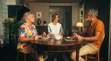 Gezinshulp aan tafel in een gezin met een persoon met dementie.